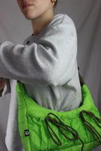 person wearing green bag with bows in puffer style 